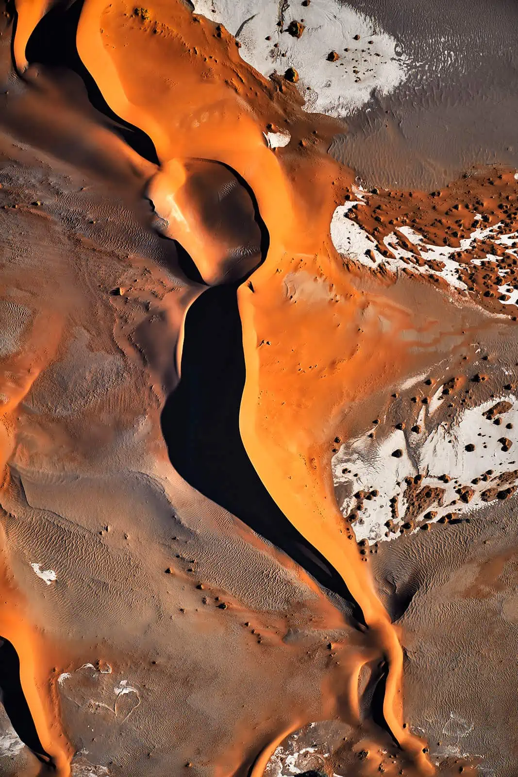 Luftbildaufnahme Wüste, beeindruckendes Farbspiel in orange, grau und weis